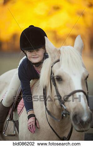 Stock Image - Caucasian girl riding on horse. Fotosearch