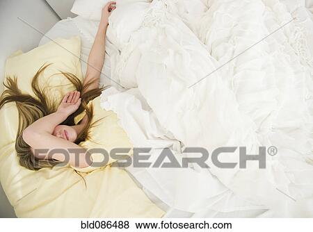 Stock Photo - Caucasian teenage girl sleeping in bed. Fotosearch