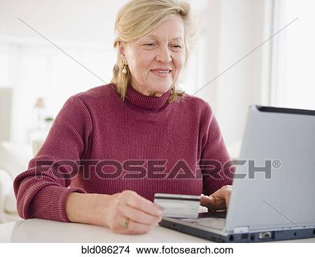 Picture - Caucasian woman shopping online with credit card. Fotosearch