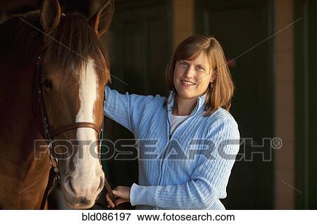 Caucasian woman standing with horse View Large Photo Image Stock Photo - Caucasian woman standing with horse. Fotosearch