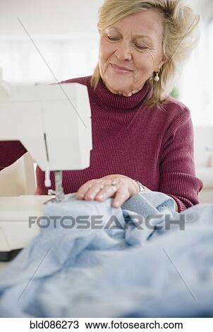 Caucasian woman using sewing machine View Large Photo Image Stock Image - Caucasian woman using sewing machine. Fotosearch