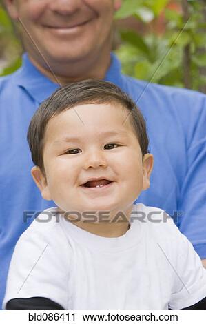 Stock Image - Chilean boy sitting on father's lap. Fotosearch