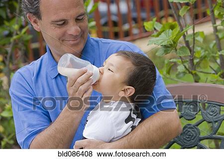 Chilean father feeding bottle to son View Large Photo Image Stock Photo - Chilean father feeding bottle to son. Fotosearch