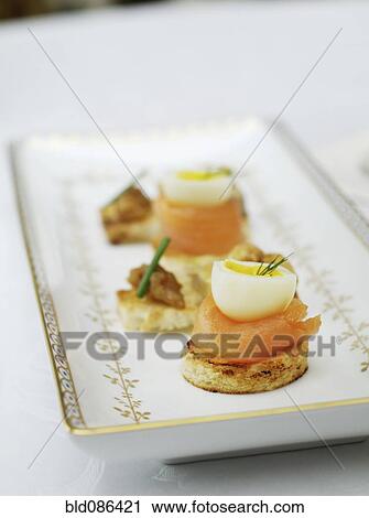 Stock Image - Close up of salmon and quail egg appetizers. Fotosearch