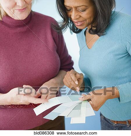 Friends looking at color swatches together View Large Photo Image Stock Photo - Friends looking at color swatches together. Fotosearch