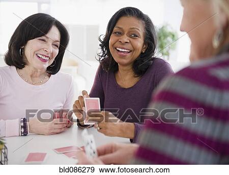 Stock Photo - Friends playing cards together. Fotosearch