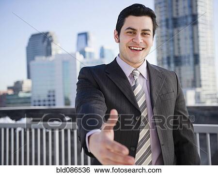 Stock Photograph - Hispanic businessman with hand outstretched. Fotosearch