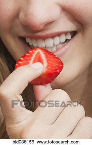 Hispanic girl eating strawberry View Large Photo Image Stock Photograph - Hispanic girl eating strawberry. Fotosearch