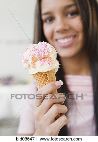 Stock Image - Hispanic teenager eating ice cream cone. Fotosearch