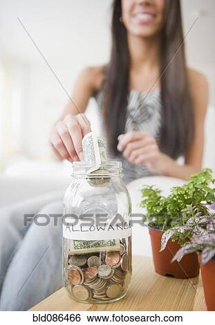 Hispanic teenager putting money into allowance jar View Large Photo Image Stock Photograph - Hispanic teenager putting money into allowance jar. Fotosearch
