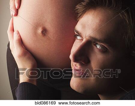 Husband listening to pregnant wife's stomach View Large Photo Image Stock Photo - Husband listening to pregnant wife's stomach. Fotosearch