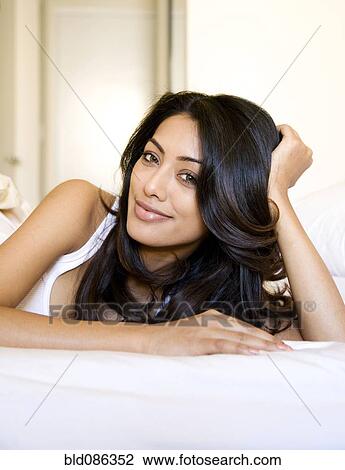 Indian woman laying on bed View Large Photo Image Stock Image - Indian woman laying on bed. Fotosearch