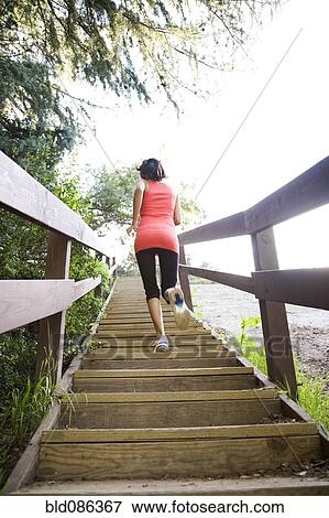 Stock Photo - Indian woman running up stairs. Fotosearch