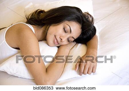 Stock Image - Indian woman sleeping in bed. Fotosearch