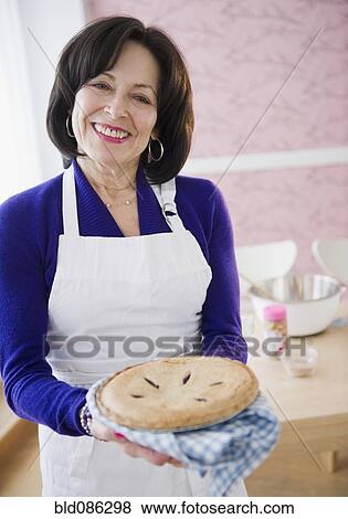 Stock Photo - Mixed race woman holding fresh baked pie. Fotosearch