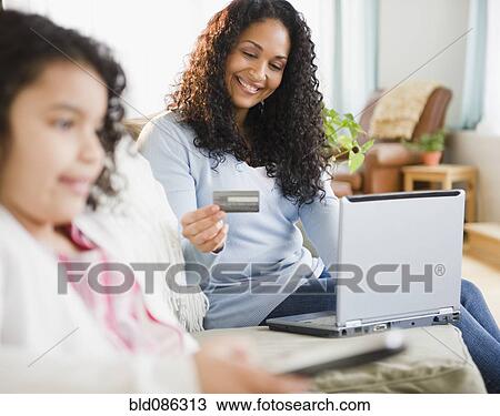 Mixed race woman shopping online with credit card View Large Photo Image Stock Image - Mixed race woman shopping online with credit card. Fotosearch