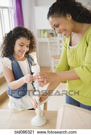Mother and daughter changing lamp lightbulb View Large Photo Image Stock Image - Mother and daughter changing lamp lightbulb. Fotosearch