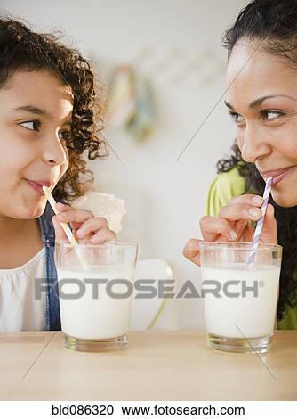 Mother and daughter drinking milk with straws View Large Photo Image Stock Image - Mother and daughter drinking milk with straws. Fotosearch