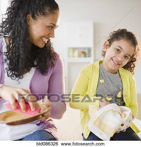 Mother and daughter drying dishes together View Large Photo Image Stock Photograph - Mother and daughter drying dishes together. Fotosearch