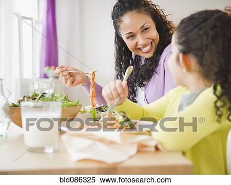 Mother and daughter eating dinner together View Large Photo Image Stock Photography - Mother and daughter eating dinner together. Fotosearch