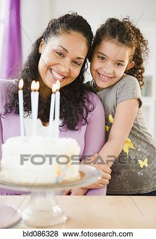 Mother and daughter standing with birthday cake View Large Photo Image Stock Photo - Mother and daughter standing with birthday cake. Fotosearch