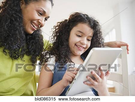 Stock Photography - Mother and daughter using digital tablet together. Fotosearch