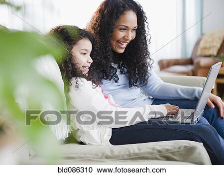 Mother and daughter using laptop together View Large Photo Image Stock Image - Mother and daughter using laptop together. Fotosearch