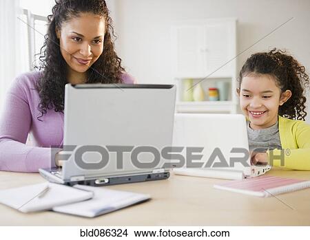 Picture - Mother and daughter using laptops together. Fotosearch