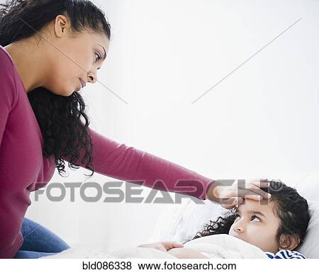Mother checking daughter's fever View Large Photo Image Stock Photo - Mother checking daughter's fever. Fotosearch