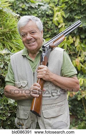 Stock Image - Senior Chilean man holding shotgun. Fotosearch