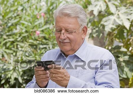 Senior Chilean man text messaging on cell phone View Large Photo Image Stock Photograph - Senior Chilean man text messaging on cell phone. Fotosearch