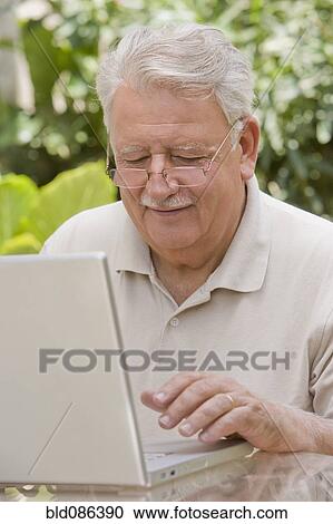 Senior Chilean man typing on laptop View Large Photo Image Stock Image - Senior Chilean man typing on laptop. Fotosearch
