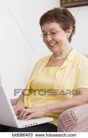 Stock Image - Senior Chilean woman typing on laptop. Fotosearch