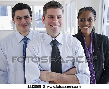 Smiling business people standing together View Large Photo Image Stock Photo - Smiling business people standing together. Fotosearch