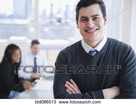 Stock Image - smiling Hispanic businessman with arms crossed. Fotosearch