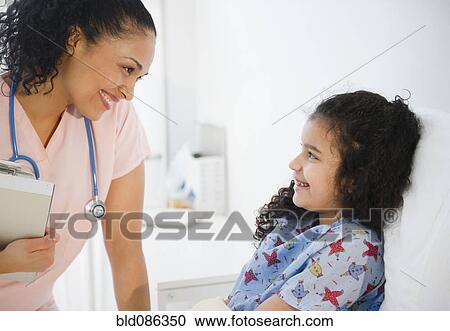 Smiling nurse talking to girl in hospital bed View Large Photo Image Stock Image - Smiling nurse talking to girl in hospital bed. Fotosearch
