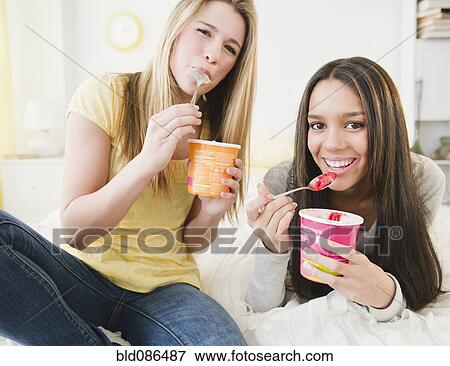 Stock Photo - Teenage girls eating ice cream together. Fotosearch
