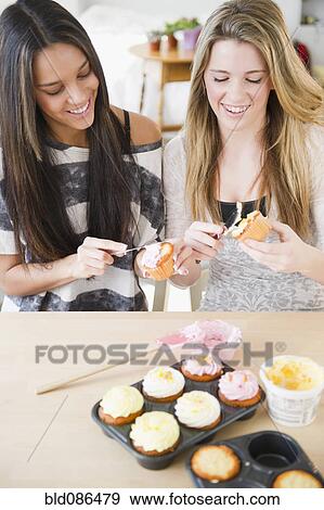 Stock Photo - Teenage girls icing cupcakes together. Fotosearch