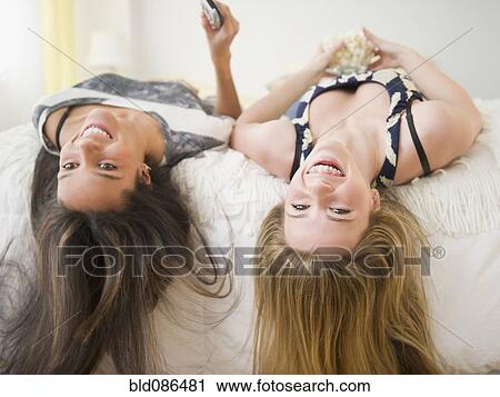 Teenage girls laying on bed upside-down View Large Photo Image Stock Image - Teenage girls laying on bed upside-down. Fotosearch