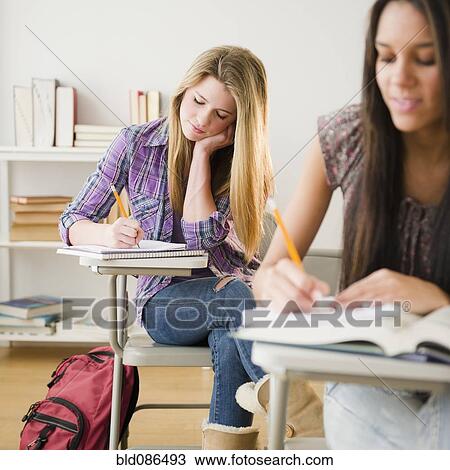 Stock Image - Teenage girls studying in classroom. Fotosearch