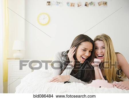 Teenage girls talking on telephone together View Large Photo Image Picture - Teenage girls talking on telephone together. Fotosearch