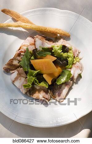 Stock Photo - Tuscany head cheese with salad, melon and breadsticks . Fotosearch