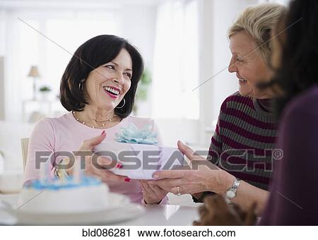 Women surprising friend with birthday cake and gift View Large Photo Image Stock Image - Women surprising friend with birthday cake and gift. Fotosearch
