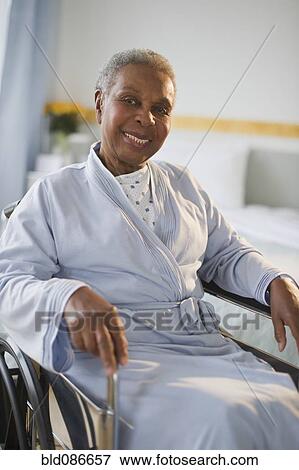 Stock Photo - Black woman sitting in wheelchair in hospital. Fotosearch