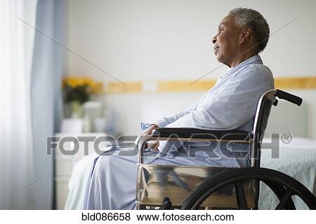 Stock Photo - Black woman sitting in wheelchair in hospital. Fotosearch