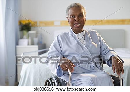 Stock Photograph - Black woman sitting in wheelchair in hospital. Fotosearch