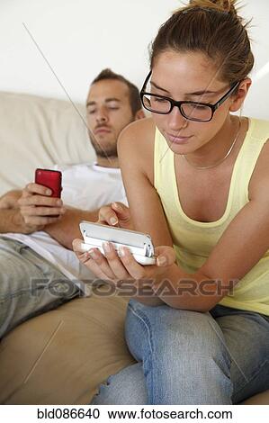 Caucasian couple laying in bed with cell phones View Large Photo Image Stock Image - Caucasian couple laying in bed with cell phones. Fotosearch