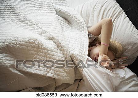 Stock Image - Caucasian teenage girl sleeping in bed. Fotosearch