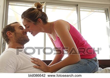 Caucasian woman sitting on husband's lap kissing him View Large Photo Image Stock Image - Caucasian woman sitting on husband's lap kissing him. Fotosearch