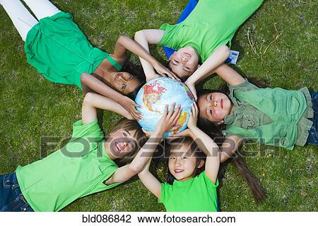 Children laying in grass around globe View Large Photo Image Stock Image - Children laying in grass around globe. Fotosearch